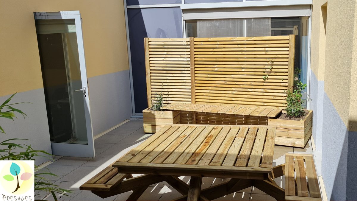 De part et d’autre du patio, des bancs pour s’installer confortablement, au milieu des plantes aromatiques et 