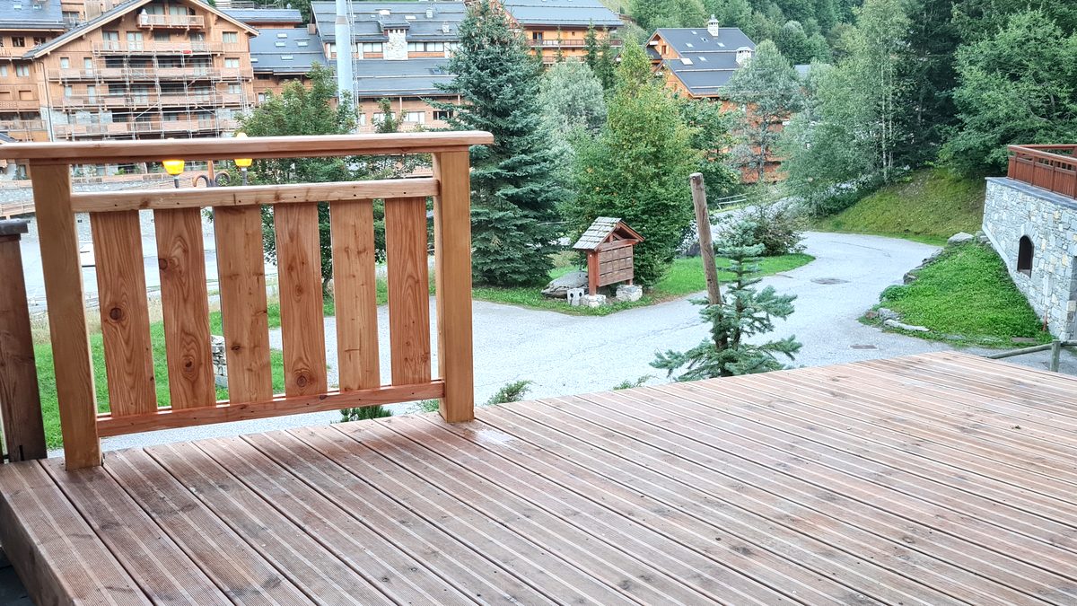 Depuis la terrasse, le garde-corps neuf et le village en contrebas