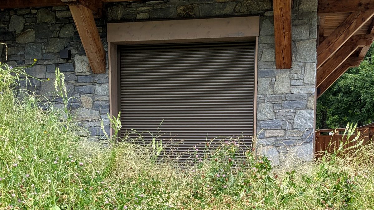 Avant les travaux, le talus d’herbes hautes monte jusqu’au mur et recouvre le bas de la baie